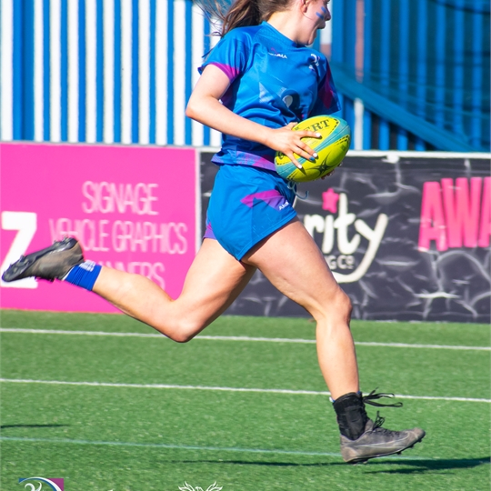 Women's Rugby union player running with the ball