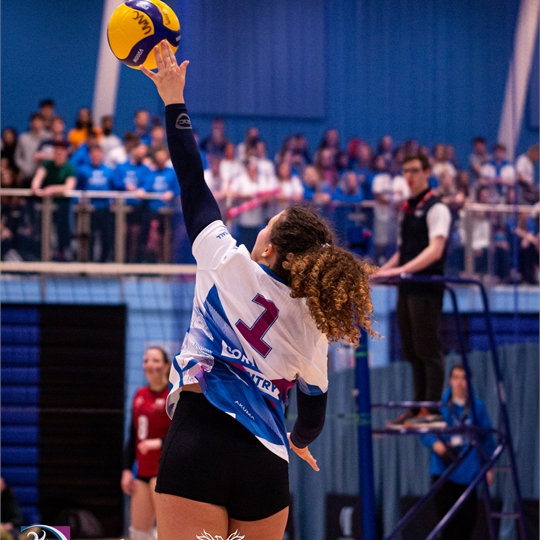 Women's Volleyball player smashing the ball
