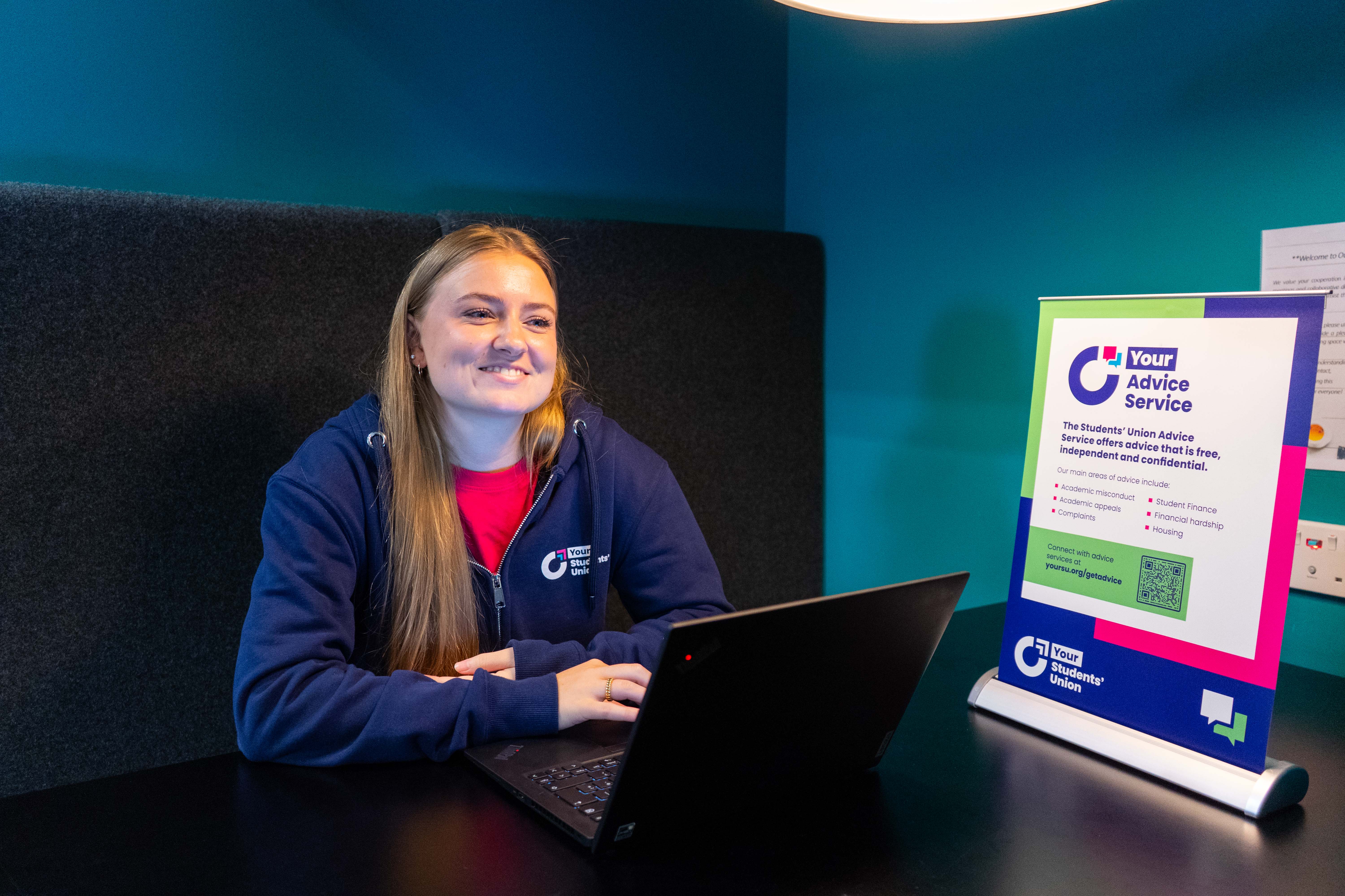 A person sat behind a table smiling.