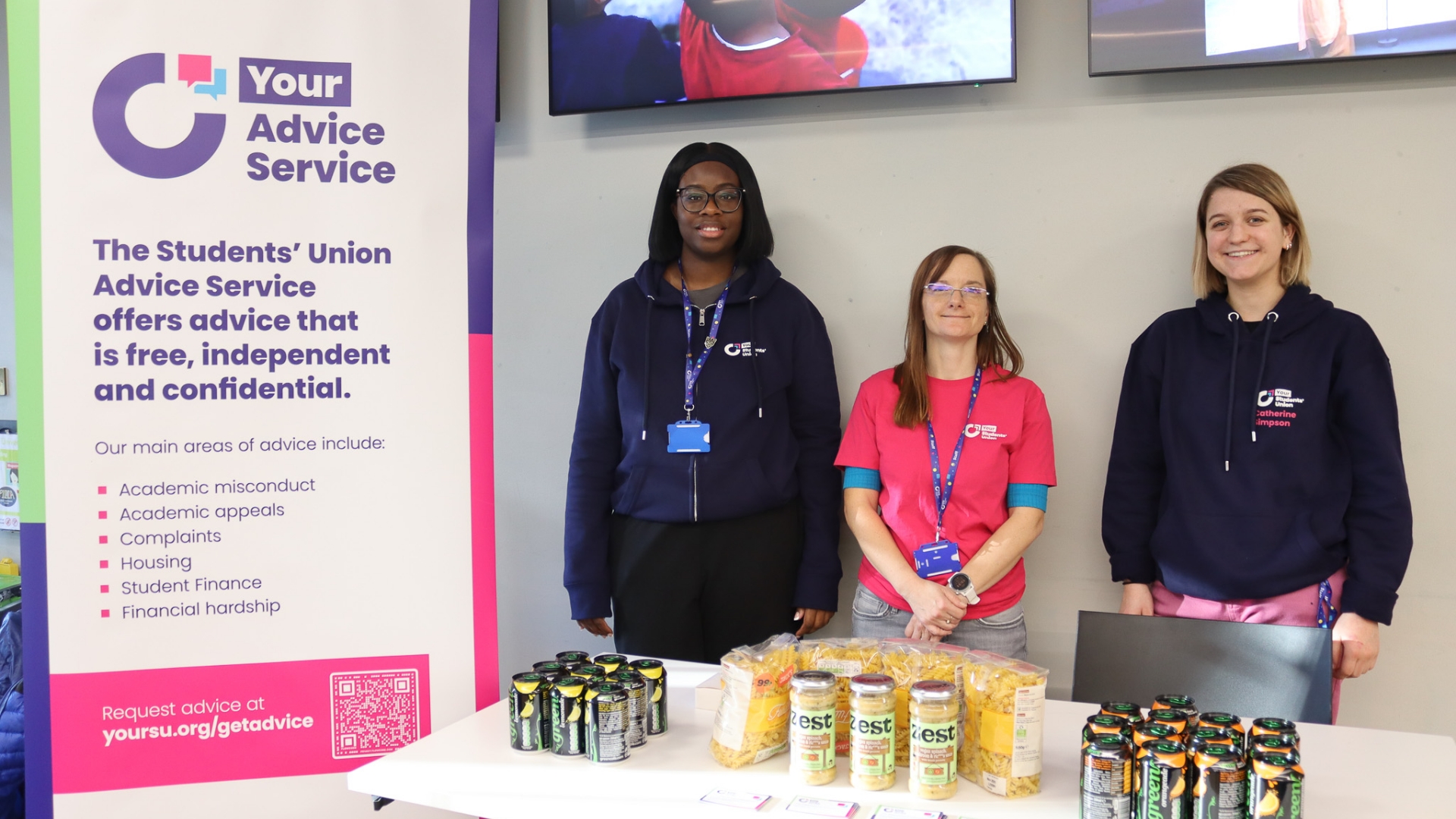 Group of SU staff standing next to a stall and table with food on it