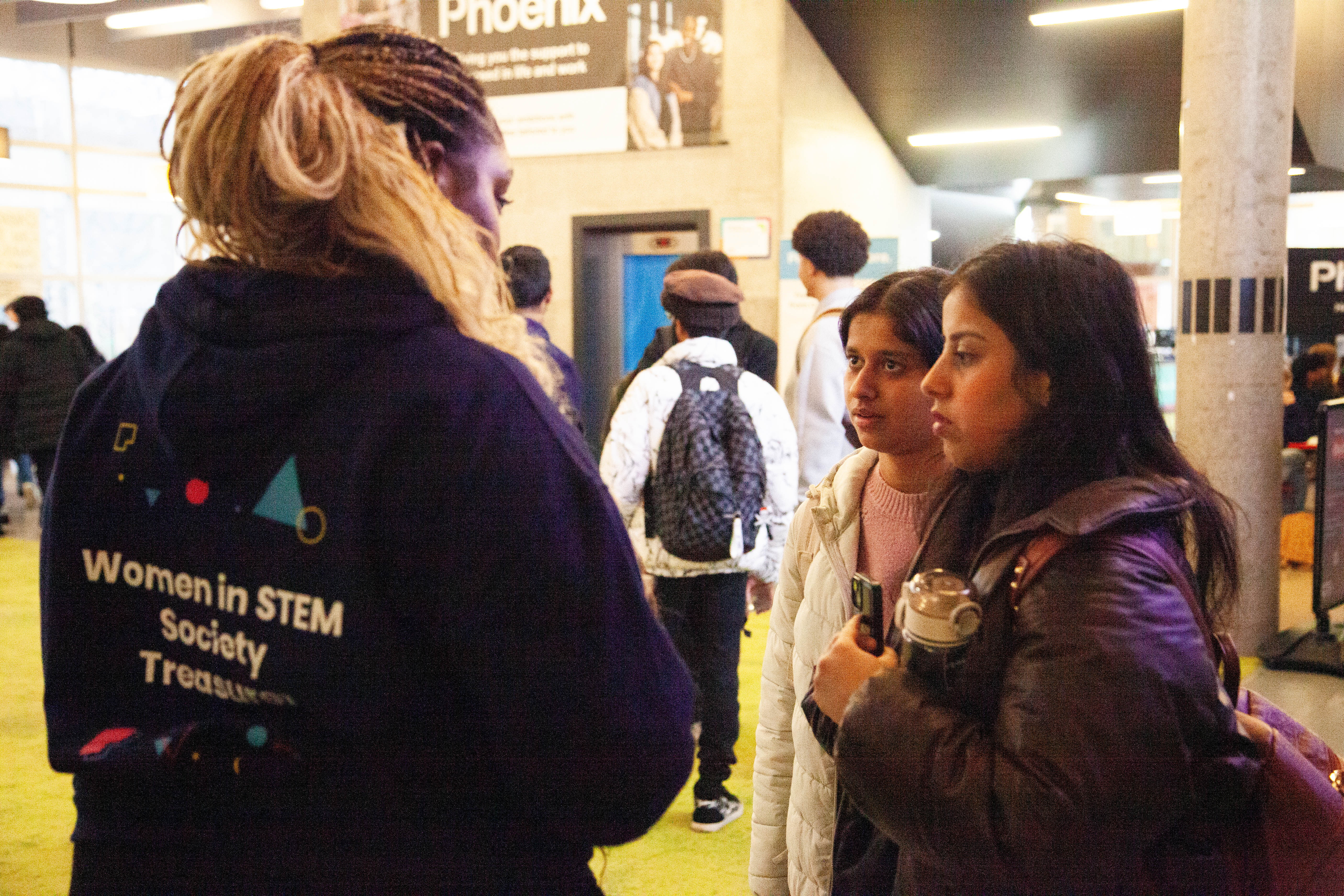 Three people standing having a conversation.