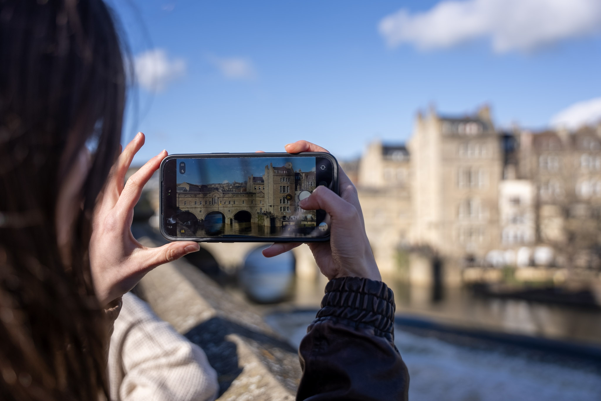 A person taking a picture of a monument on their phone.