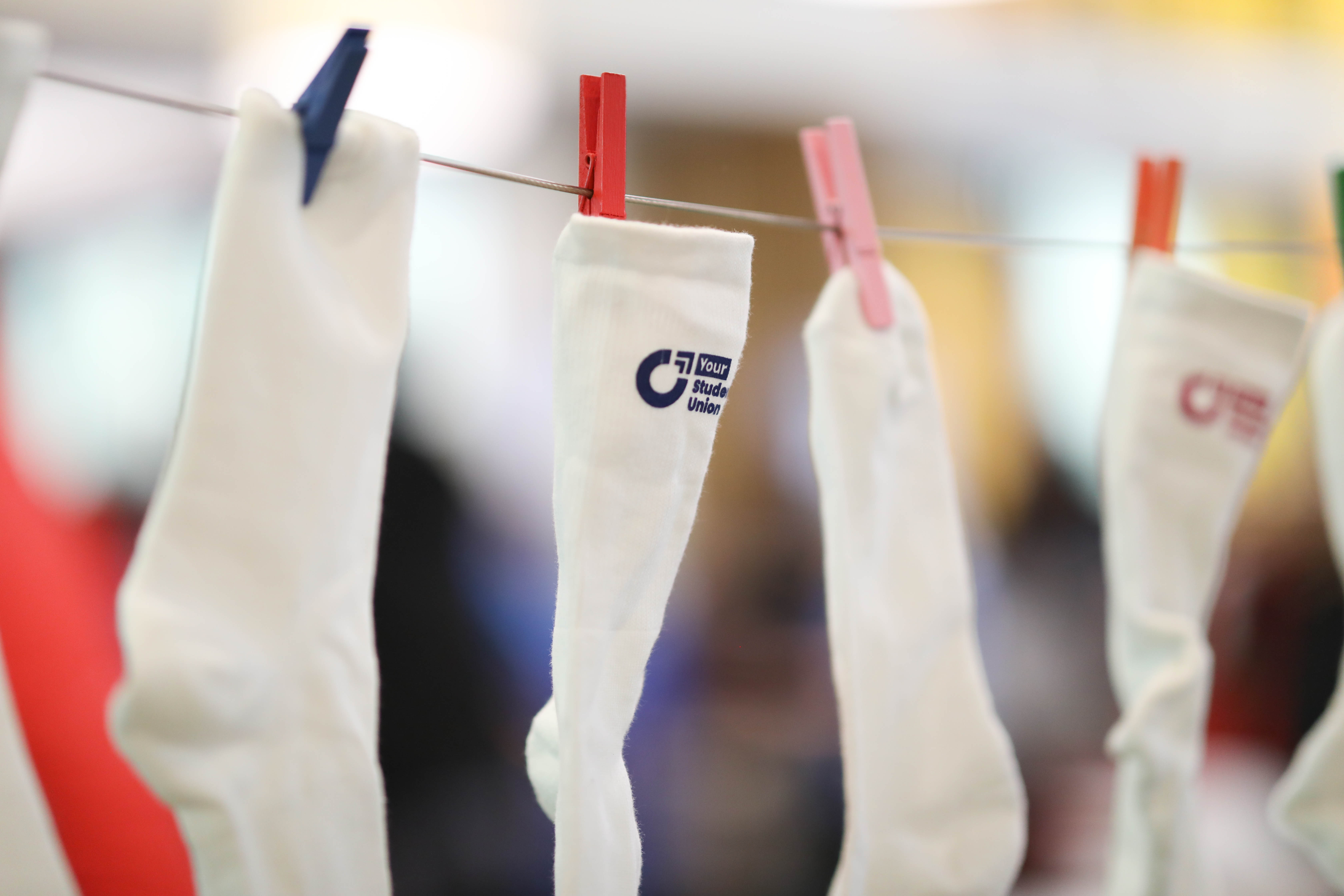 SU-branded socks hanging on a line.