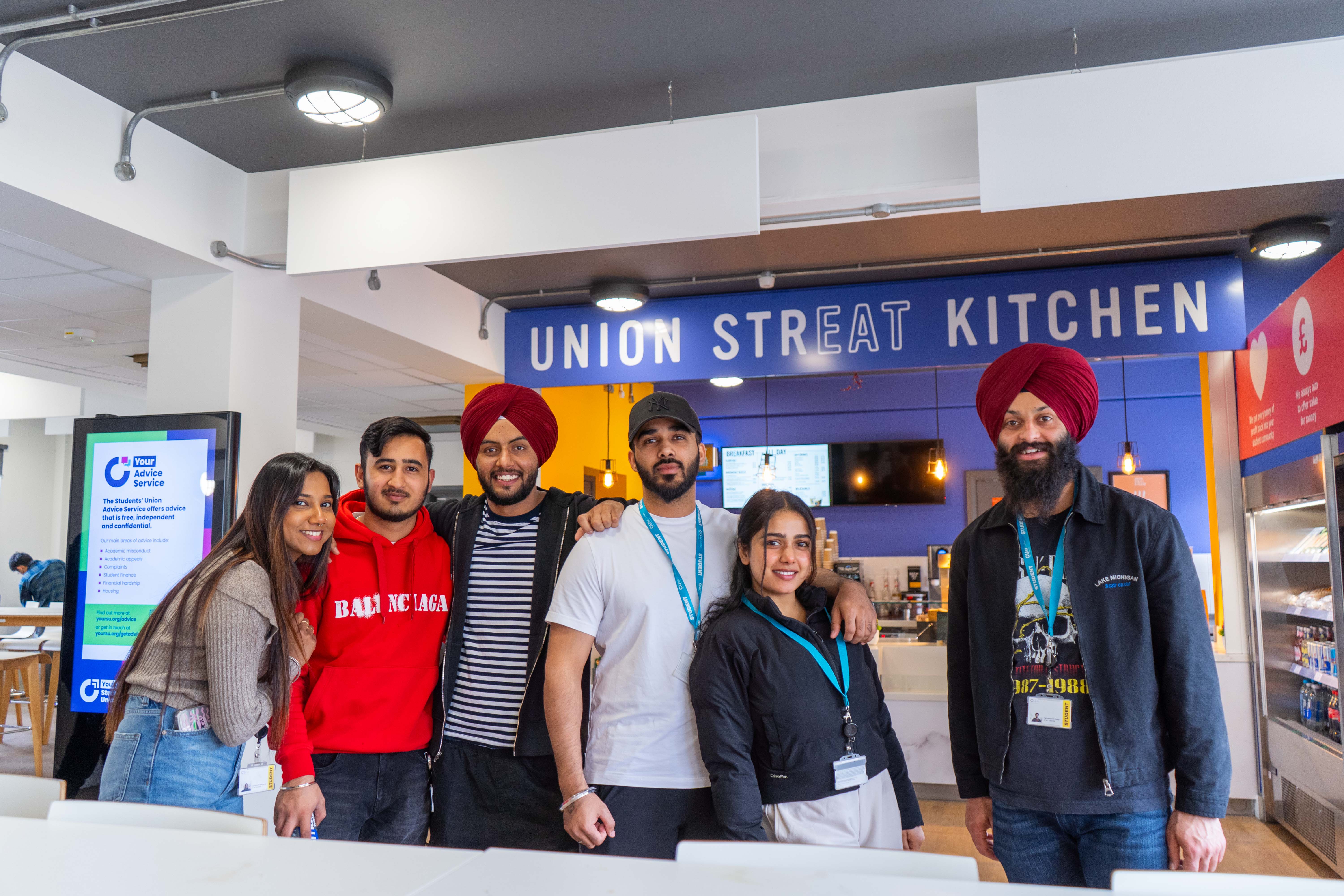 A group of people standing in a line smiling.