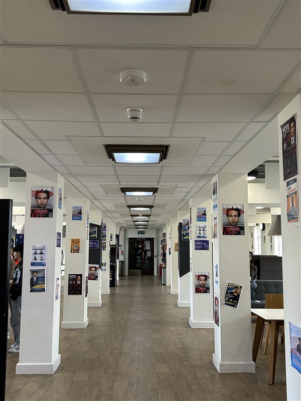 A corridor with candidate posters placed on bollards.