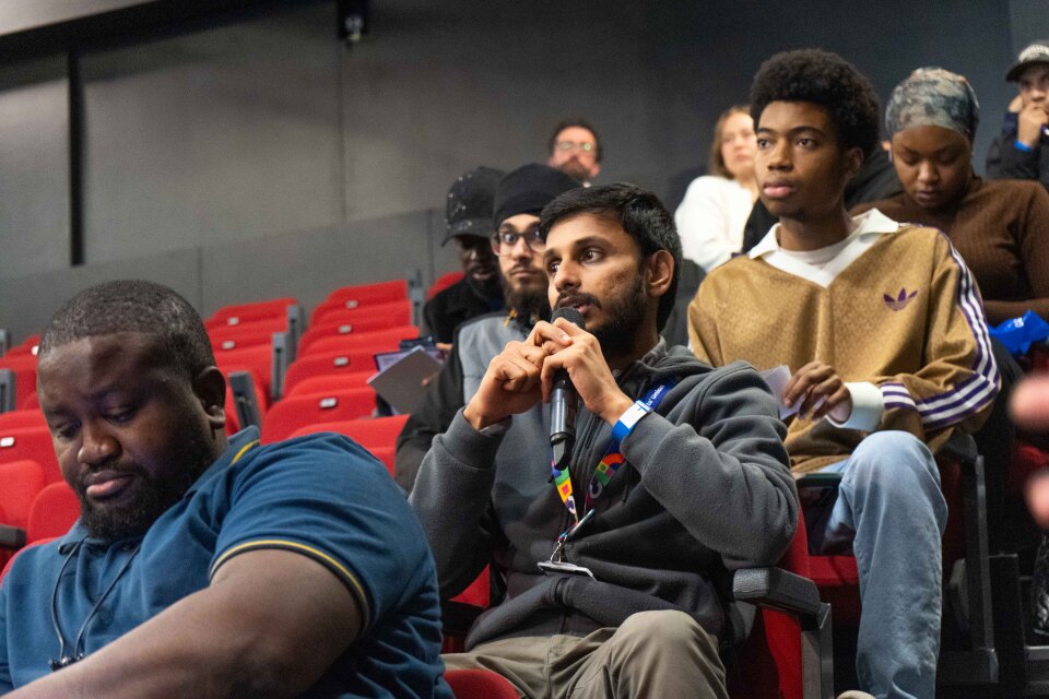 People sat down with one speaking into a microphone.