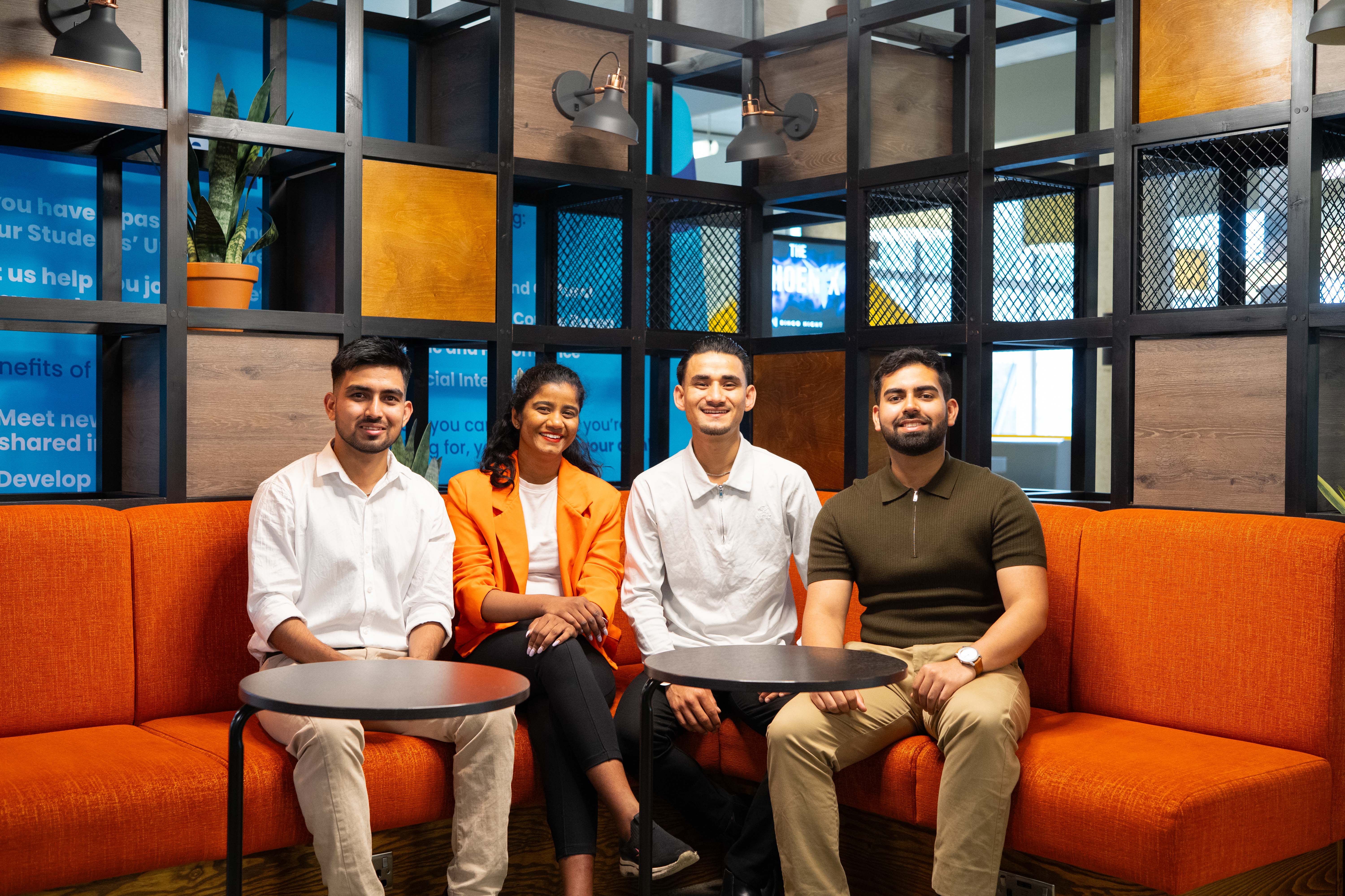 Four people sat on a sofa inside The Hub.