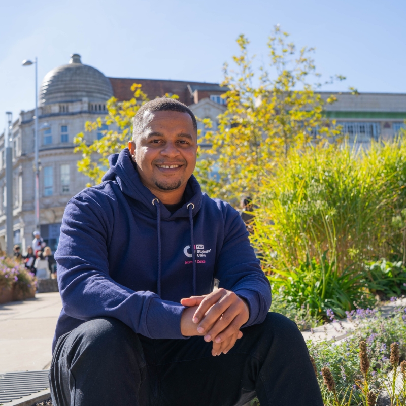 A person sat and smiling staring into the camera.