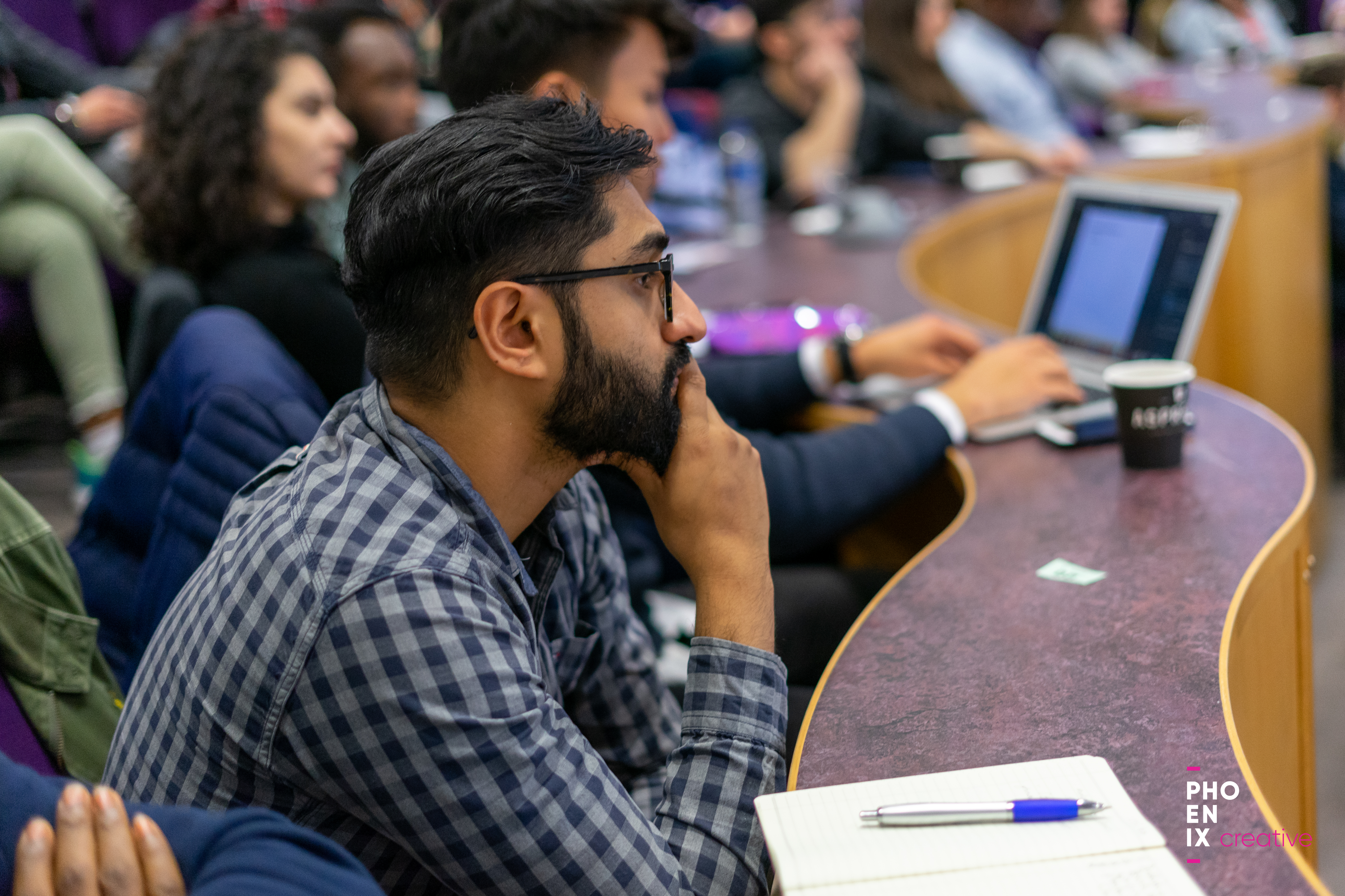 A student sat in a lecture hall looking on.